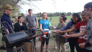 An image of students making smores around an experiment.